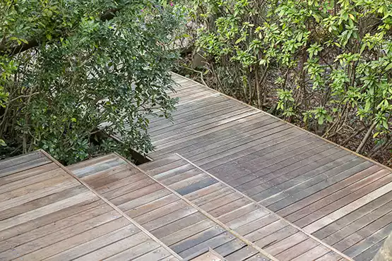 A deck with a railing and stairs leading up to a door